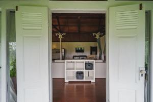 une cuisine avec deux portes s'ouvrant sur une chambre dans l'établissement Rumah Jembarati, à Cangkringan