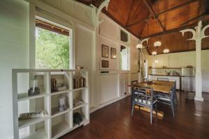 a dining room with a table and a kitchen at Rumah Jembarati in Cangkringan