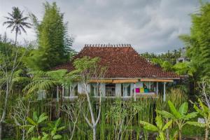 une maison au milieu d'une forêt d'arbres dans l'établissement Rumah Jembarati, à Cangkringan
