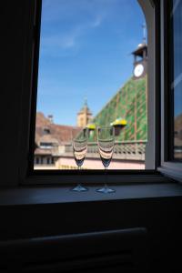 two wine glasses sitting on a window sill at SECRET MAMA with Aircon 150 meters from parking Rapp in Colmar