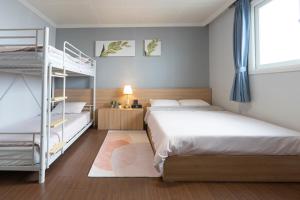 a bedroom with two bunk beds and a ladder at Ellui Hotel Jeju in Jeju