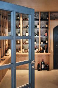 a door in a room with bottles of alcohol at Haller Suites & Restaurant in Bressanone