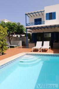 een zwembad met twee stoelen en een huis bij VILLA DUNIA by Villitas in Playa Blanca
