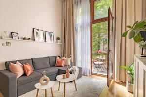 - un salon avec un canapé gris et 2 tables dans l'établissement KAZ13 Kazinczy Apartment, à Budapest 45 autres photos