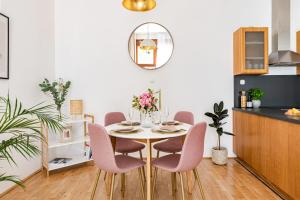 - une salle à manger avec une table, des chaises et un miroir dans l'établissement KAZ13 Kazinczy Apartment, à Budapest