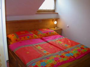 a bed with a colorful comforter in a bedroom at Appartement Luisa in Bad Kleinkirchheim