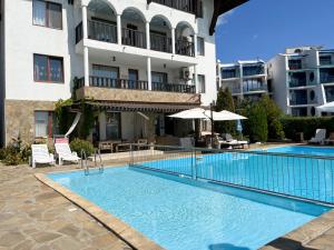 a swimming pool in front of a building at Комплекс «ТОП» in Sveti Vlas