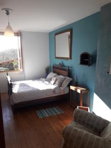 a bedroom with a bed and a couch and a window at Maison et Jardin Talinou in Montastruc