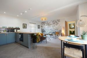 a kitchen and living room with blue cabinets and a table at Kin Ludlow Rooms in Ludlow