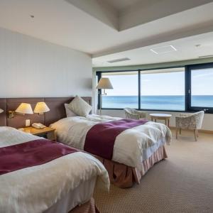 a hotel room with two beds and a view of the ocean at Onahama Ocean Hotel & Golf Club in Iwaki