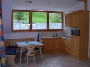 a kitchen with wooden cabinets and a table with chairs at Appartement Luisa in Bad Kleinkirchheim