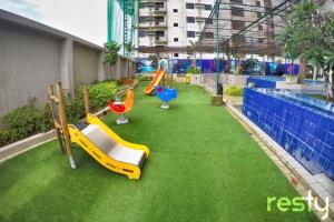 a playground with slides on the grass in a building at Jojie's Crib in Cebu City