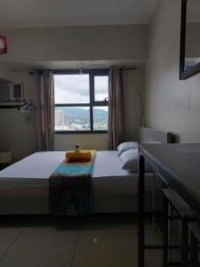 a bedroom with a large bed with a window at Jojie's Crib Horizons101 Studio II in Cebu City +26 photos