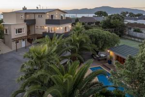 uma vista aérea de uma casa com piscina e árvores em Kapiti Getaway - Paraparaumu Beach Rental em Paraparaumu Beach