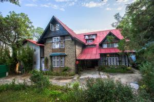 a large house with a red roof at StayVista at Northwood Cottage with Vintage Luxury in Shimla