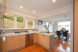 a large kitchen with a counter and a dining room at City Views on Rattray in Dunedin