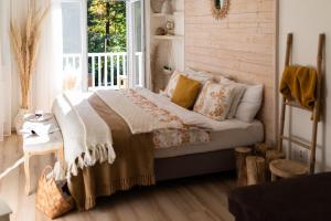um quarto com uma cama com almofadas e uma janela em Magnólia em Nagykanizsa