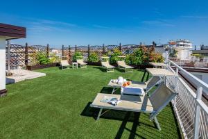 a balcony with a table and chairs on the grass at Hotel Villa d'Este in Grado
