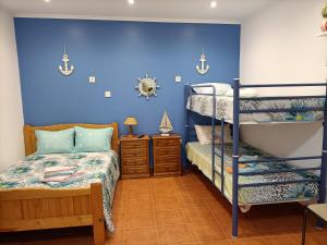 a bedroom with two bunk beds and a blue wall at Estúdio Mário Fanha in Nazaré