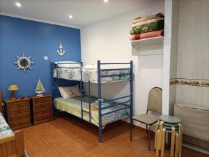 a bedroom with two bunk beds and a blue wall at Estúdio Mário Fanha in Nazaré +7 photos
