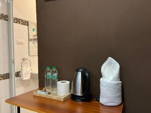 a counter with toilet paper and water bottles on it at Cozy rooms Asoke in Bangkok