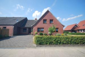 a brick house with a driveway in a yard at Ferienhaus Irma 35530 in Uplengen