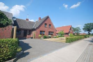a red brick house with a driveway at Ferienhaus Irma 35530 in Uplengen