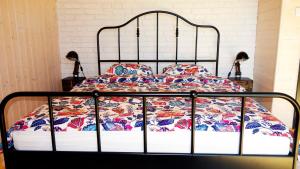 an iron bed with a colorful quilt on it at Domek Dzikie Lisko in Lesko