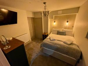 Dormitorio con cama, escritorio y TV en College Hill Shrewsbury, en Shrewsbury