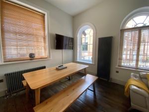 a living room with a wooden table and two windows at College Hill Shrewsbury in Shrewsbury