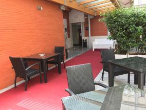 a patio with tables and chairs on a red carpet at Hotel Boutique Gareus in Valladolid
