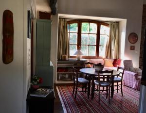 ein Wohnzimmer mit einem Tisch und Stühlen in der Unterkunft Gîte Maison Maitri in Forgès