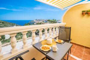 a table and chairs on a balcony with a view of the ocean at Casa Frederyk in Cumbre del Sol