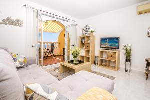 ein Wohnzimmer mit einem Sofa und einem TV in der Unterkunft Casa Frederyk in Cumbre del Sol