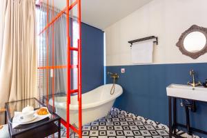 een badkamer met een wit bad en blauwe muren bij Shota Rustaveli Aparthotel in Tbilisi City