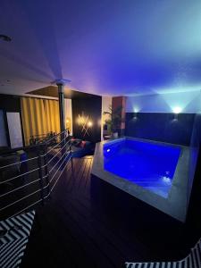 a large blue swimming pool in a room with at Nyx suite d’exception in Dijon