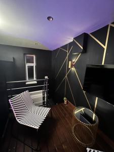 um quarto com uma mesa de madeira e um tecto roxo em Nyx suite d’exception em Dijon