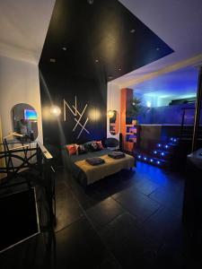 a room with a bed in a room with blue lights at Nyx suite d’exception in Dijon