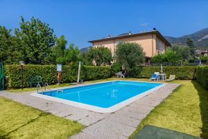 a swimming pool in the yard of a house at Residence Mimosa PT2 by Wonderful Italy in Toscolano Maderno