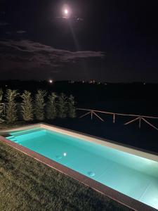 a swimming pool at night with the moon in the sky at La Casa del Tiglio in Mombaruzzo