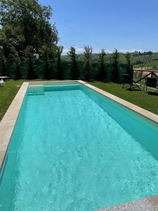una piscina de agua azul en un patio en La Casa del Tiglio, en Mombaruzzo