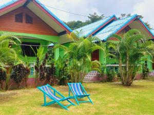 duas cadeiras azuis sentadas em frente a uma casa em Papaya Cottage Koh Chang em Ko Chang