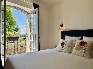 a bedroom with a bed with a view of a balcony at La Villa 1777 in Lagnes