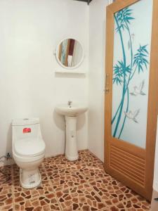 a bathroom with a toilet and a sink and a mirror at Good Time Resort Koh Kood in Ban Lak Uan
