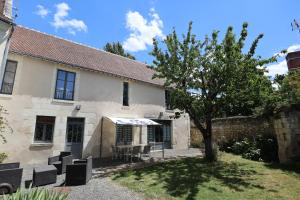 uma casa com cadeiras e uma árvore no quintal em Le Grand Presbytère de Beaulieu em Beaulieu-lès-Loches