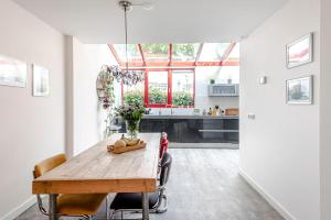 a kitchen and dining room with a wooden table and chairs at B&B De Ranck in Haarlem