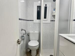 a white bathroom with a toilet and a sink at Apartamento el Cau, acogedor y cerca del Montseny in Arbúcies