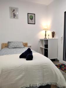 ein Schlafzimmer mit einem Bett mit einem blauen Kissen darauf in der Unterkunft Apartamento el Cau, acogedor y cerca del Montseny in Arbúcies