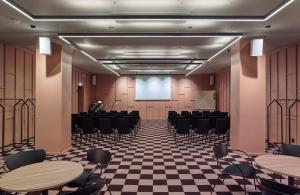 una sala de conferencias con mesas y sillas y una pantalla de proyección en Scandic Park, en Estocolmo