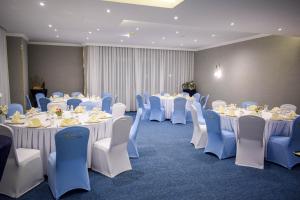 una habitación llena de mesas y sillas con manteles blancos en Saraya Corniche Hotel en Doha